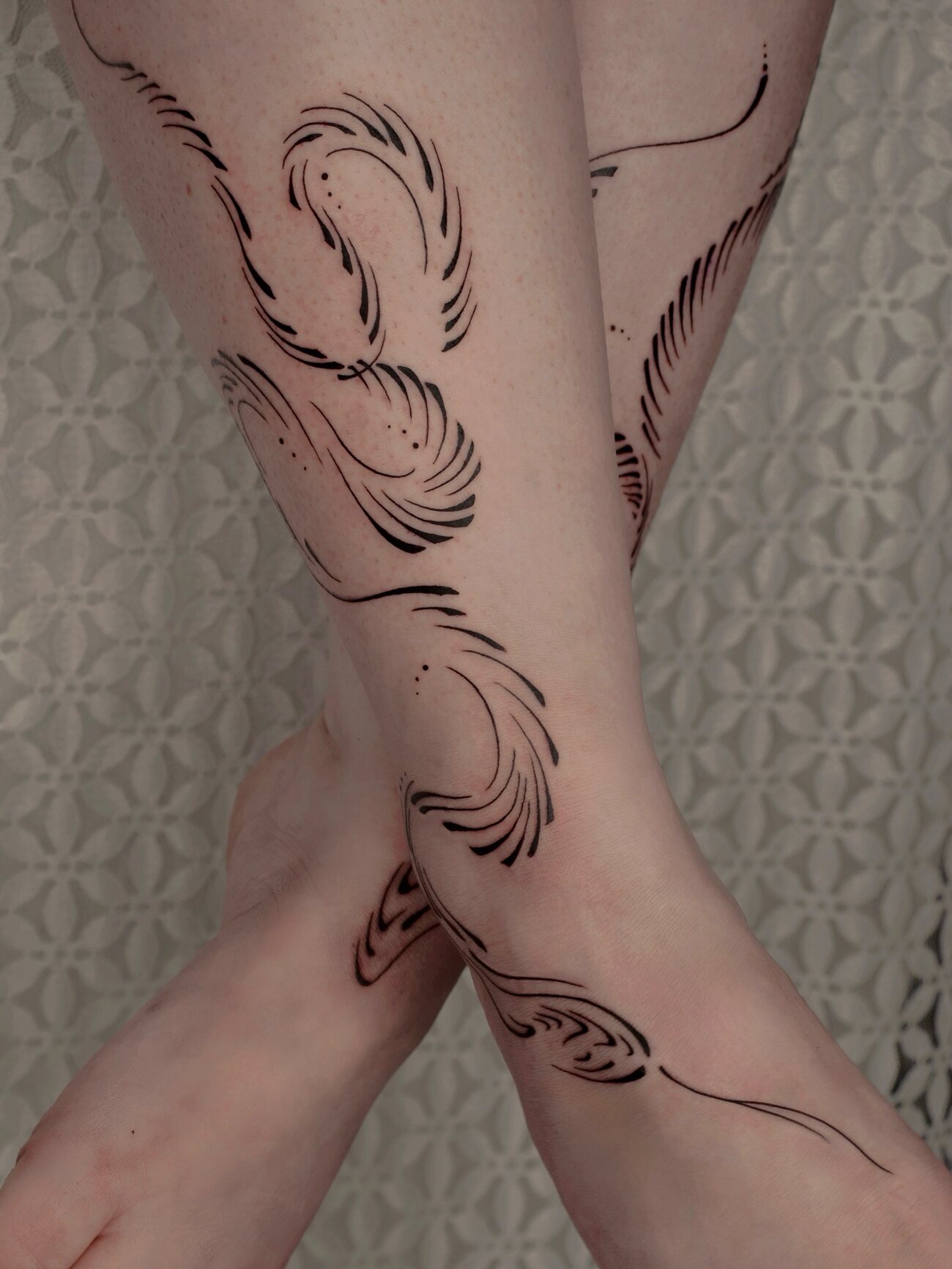 Tatouage bio-organique sur les jambes, lignes abstraites, par Clara Guilloud